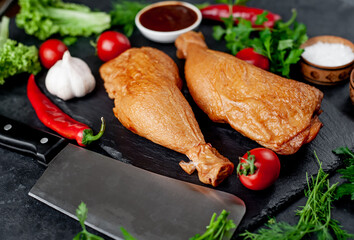 Smoked chicken thighs with spices on a stone background