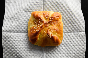 Baking food made of dough stuffed on a platter. Fast food photo subject on a black background.