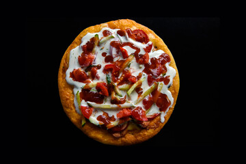 Pizza isolated on a black background. Fast food photography subject.