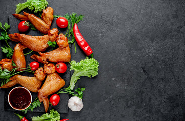 Smoked chicken wings with spices on a stone background 
with copy space for your text