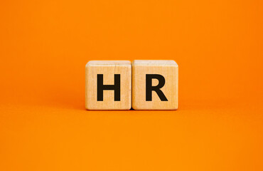 Wood cubes with letteres hr on beautiful orange background, copy space. Business, employment and human resources conceptual image.