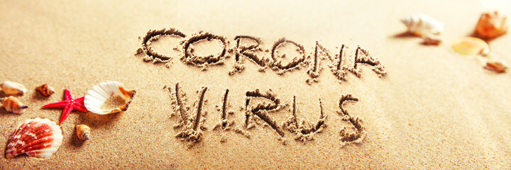 Corona virus written in the sand on vacation