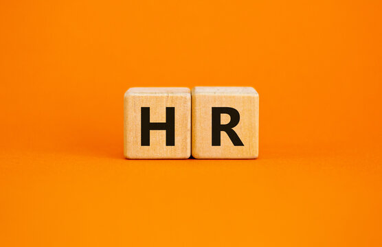 Wood cubes with letteres hr on beautiful orange background, copy space. Business, employment and human resources conceptual image.