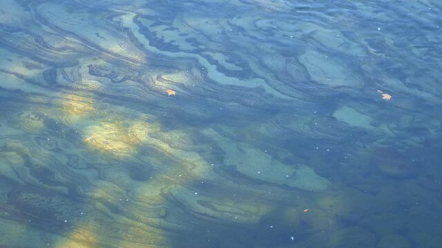 beautiful striped rocky bottom of the river under clear water in shallow water