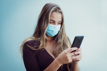 Girl Wearing mask due coronavirus uses phone
