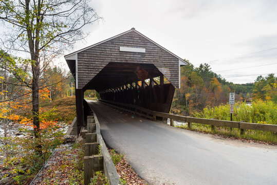 Historic covered bridge in the countryside of New Hampshire in autumn. Lens flare and autumn colours. Bath, NH, USA.