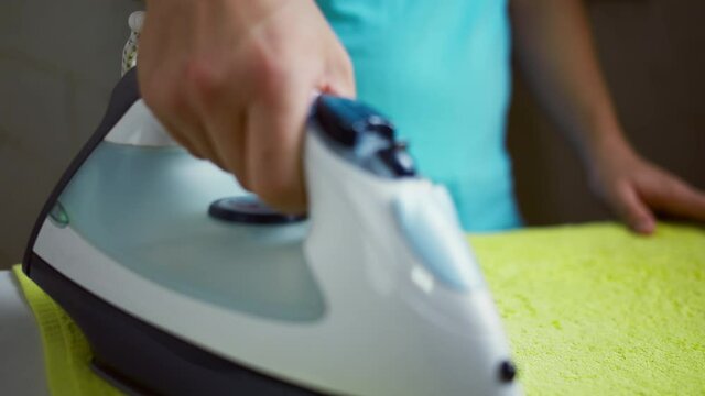 Iron with water spray, a man ironing a terry towel, ras focus
