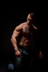 Fototapeta na wymiar Young muscular guy in the studio, posing for the camera