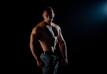 Fototapeta na wymiar Portrait of strong man showing muscles isolated on black