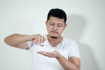 a young man holding a lot of pills in hand
In a white background