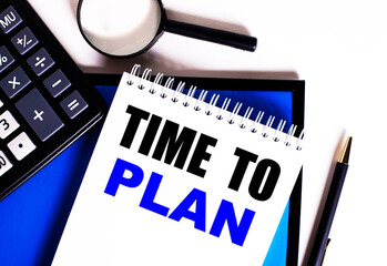 TIME TO PLAN is written on a white notepad next to a calculator, pen and magnifier. Business concept