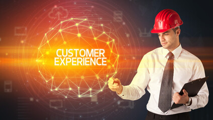 Handsome businessman with helmet drawing CUSTOMER EXPERIENCE inscription, social construction concept