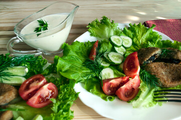 portion of potato cutlets on a plate with vegetables and greens. Selective focus.