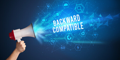 Young woman shouting in megaphone with BACKWARD COMPATIBLE inscription, Modern technology announcement concept