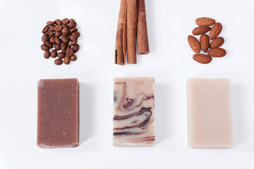 Three different types of hand-made soaps: coffee, cinnamon and almond on a white background.
