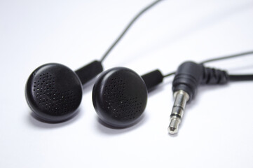 Black earphone with apparent wires and white background