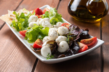Insalata fresca di verdura, pomodori e mozzarelline con olio extra vergine di oliva e un pizzico di origano  