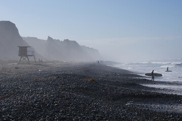 Surfer wading in on the coast