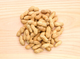 Dried peanuts in closeup on wooden board