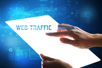Hand holdig futuristic tablet with WEB TRAFFIC inscription, new technology concept