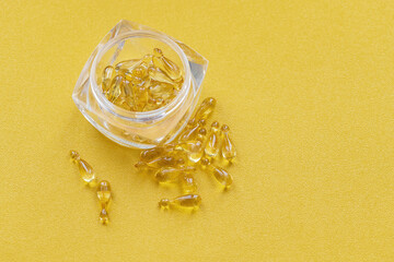 Pharmaceutical medicine tablets, capsules with vitamin D on a bright yellow background.