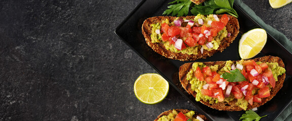Close up of two vegan avocado sandwiches with tomato pieces