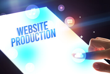 Holding futuristic tablet with WEBSITE PRODUCTION inscription, new technology concept