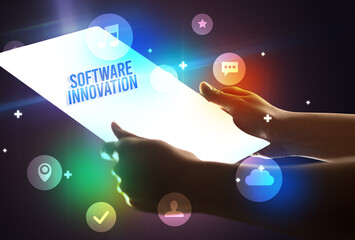 Holding futuristic tablet with SOFTWARE INNOVATION inscription, new technology concept