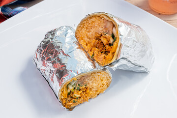 Delicious chicken burrito with rice, beans, cilantro, and vegetables. Mexican food from a food cart. 