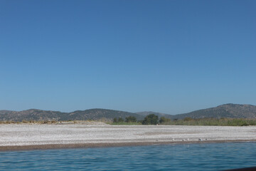 View of Fort from the Ocean. Still Waters with Cliffs. Still blue ocean waters with fort in the background distance. Cliff shores