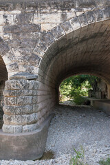 arched stone bridge over a dry creek bed
