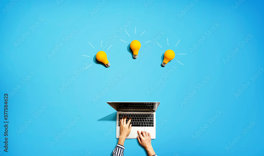 Poster person using a laptop computer with three light bulbs from above
