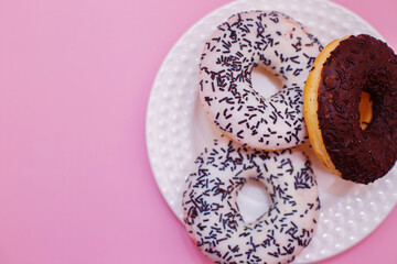 Pink sweet doughnuts on a white plate for tea, sweets