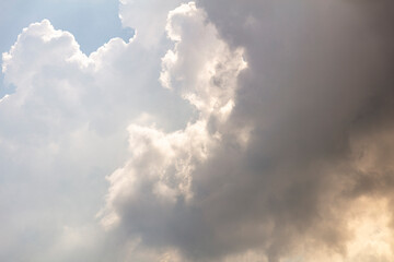 Fototapeta premium Looking up to moody clouds, weather is changing visibly in the sky and rain is on the way. sunlight is creeping through. Textured graphic design resource