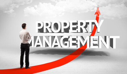 Rear view of a businessman standing in front of PROPERTY MANAGEMENT inscription, successful business concept
