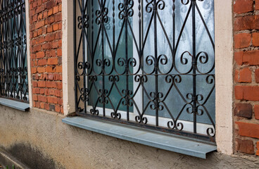 The fa ade on the side. Windows with iron bars with the ligature