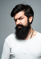 Portrait of confident serious man. Hipster guy models in studio. Handsome male model on gray background.