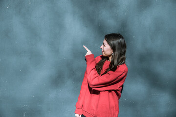 young woman pointing to a copy space point, advertising concept, man, woman, smooth wall