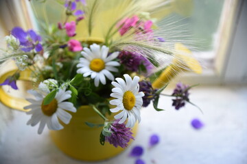 Summer wildflowers in a vase on the window