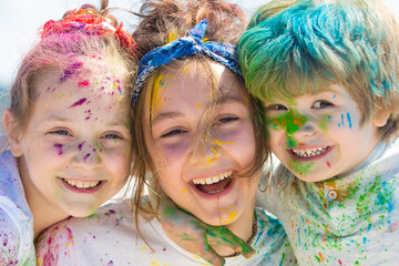Close up portrait of happy excited litttle kids on holi color festival. Cute children with colorful paint powder on faces.