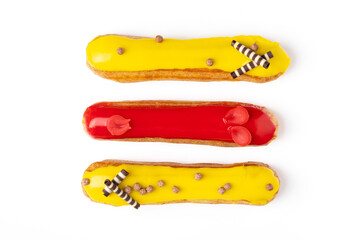 French glazed eclairs with lemon and strawberry cream, sweet dessert on white