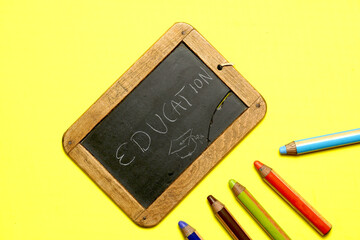 blackboard with the word education written with colorful paints. flat lay