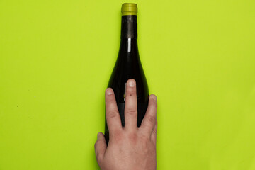 Top view of man's hand over wine bottle. flat lay