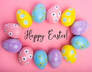 Colorful Easter eggs on pink background with greeting 