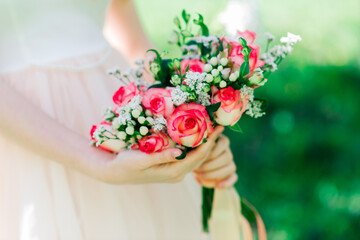 Obraz na płótnie Canvas Wedding bouquet of white and red roses in bride's hands