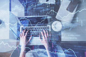 Double exposure of woman hands working on computer and forex chart hologram drawing. Top View. Financial analysis concept.