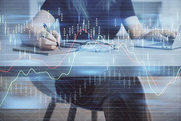 Double exposure of businesswoman hands typing on computer and forex chart hologram drawing....
