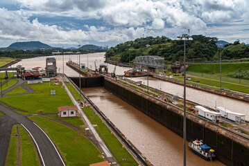 City of Knowledge, Panama - November 30, 2008: Miraflores locks. View to Pacific Ocean from the locks under cloudscape and green mountains in back. Only small boat present.