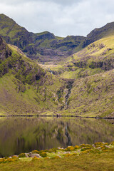View across a calm Loch Cruite towards the Eastern Corrie and Valley below Brandon Mountain on the Dingle Peninsula in County Kerry, Ireland