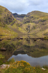 Looking Northwest along a calm Loch Cruite towards the Eastern Corrie and Valley below Brandon Mountain on the Dingle Peninsula in County Kerry, Ireland